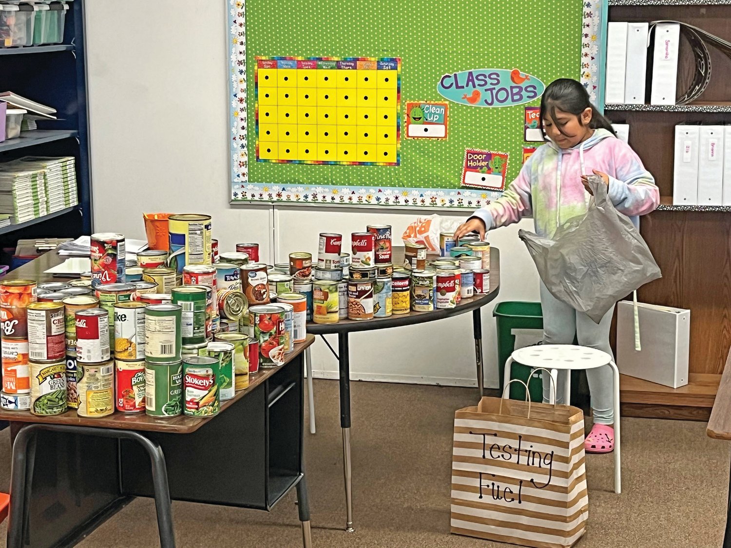 This photo is of a student unpacking canned good in her class room.